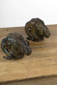 Pair of patinated bronze rams' heads