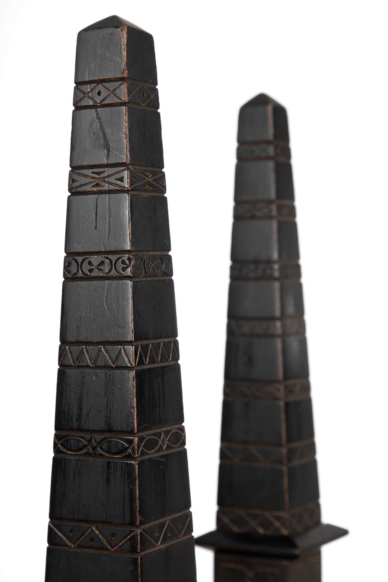 Antique ebonised incise-carved library obelisks